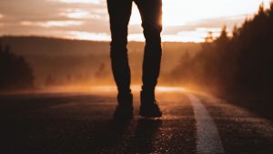 A silhouette of a person walking down a road at sunset, symbolizing the first step to freedom from pornography.